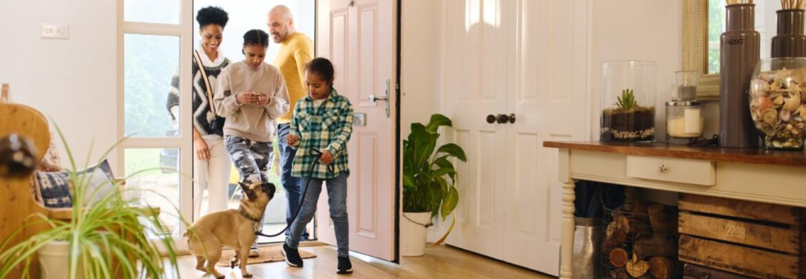 a family walking into their new home with their dog.