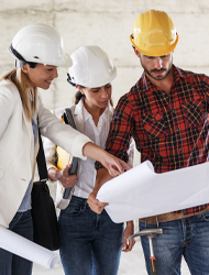 three construction workers reviewing building plans