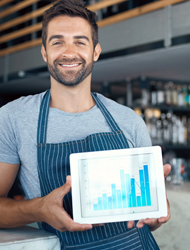 a small business owner holding his tablet