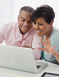 a couple viewing their laptop computer